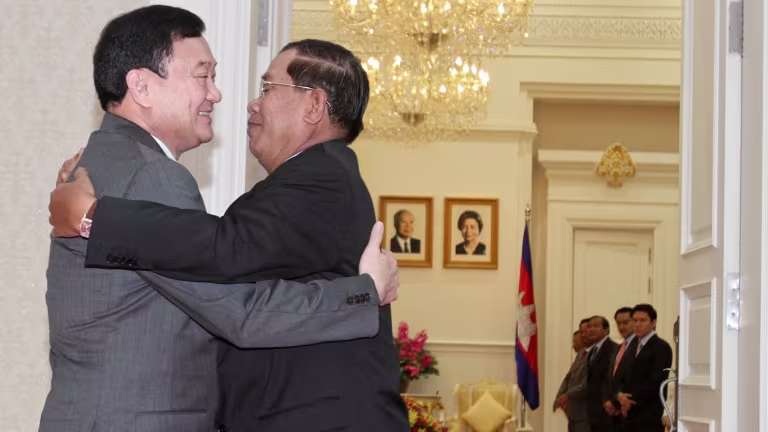 Bekas Perdana Menteri Thailand Thaksin Shinawatra, kiri, memeluk Perdana Menteri Kemboja ketika itu Hun Sen di Majlis Menteri di Phnom Penh, pada September 2011. © Reuters