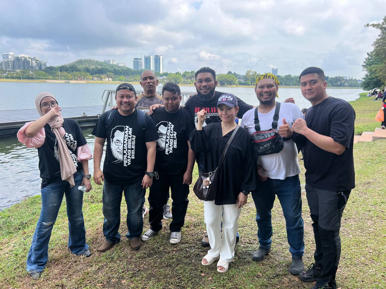 Kumpulan lelaki bergambar di tepi tasik.